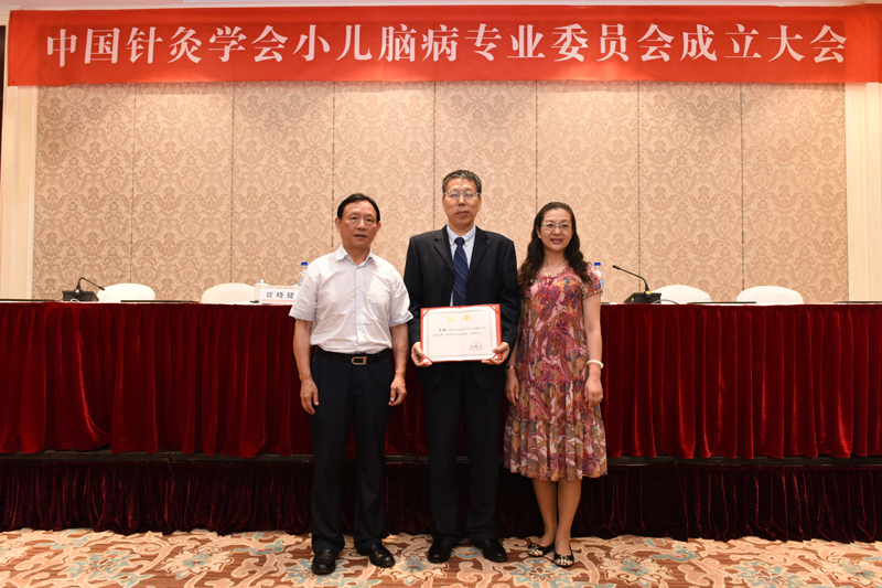 中国针灸学会副会长王华和副秘书长贾晓健为新当选主任委员颁发证书.jpg